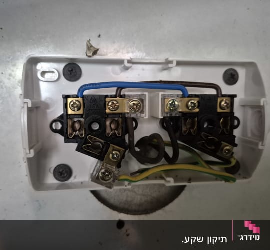 חיבורי חשמל בתוך קופסה לבנה עם חוטים צבעוניים